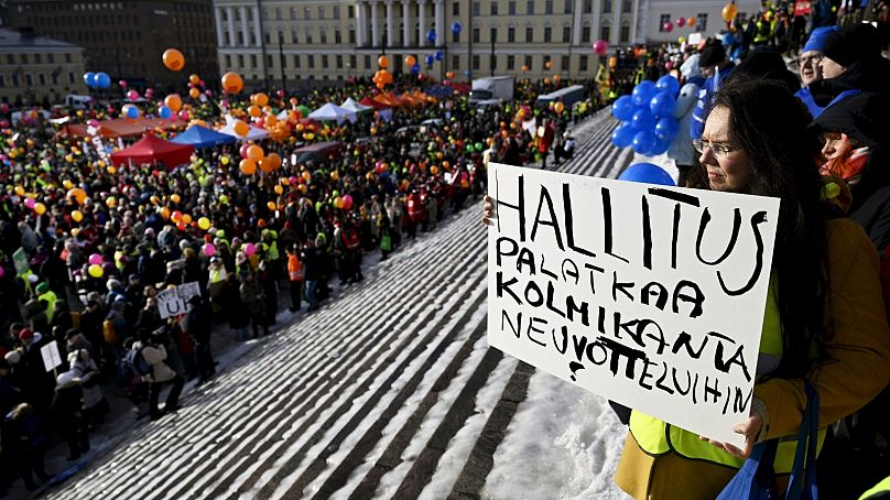 Striking worker holds sign which reads (Finnish) "Government, return to tripartite negotiations" in Helsinki, 1 February 2024