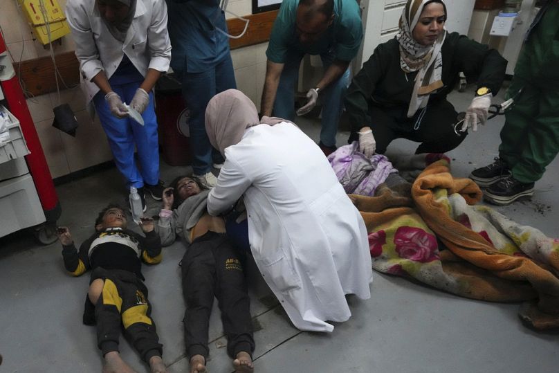 Palestinians wounded in the Israeli air and ground offensive on the Gaza Strip are brought to a hospital in Deir al Balah on Friday, Jan. 26, 2024.