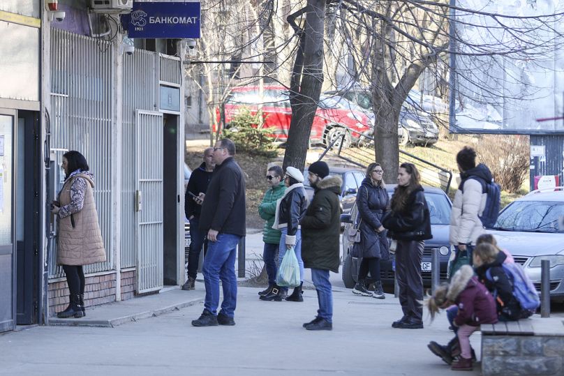People line up at a cash machine in northern Serb-dominated part of ethnically divided town of Mitrovica