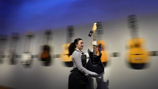 Mark Knopfler’s guitars sell for more than €10million at auction - here: A Christie's employee moves a guitar owned by Knopfler