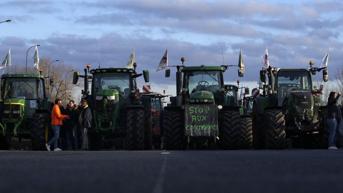 A megszorítások ellen tiltakozó gazdák traktorai egy elzárt autópályán