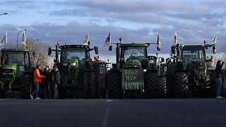 A megszorítások ellen tiltakozó gazdák traktorai egy elzárt autópályán