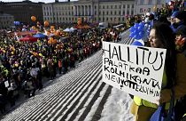 Kirsi Harju sostiene una pancarta en Stop Now! Manifestación contra las reformas laborales del Gobierno de Finlandia en Helsinki, Finlandia, el 1 de febrero de 2024.