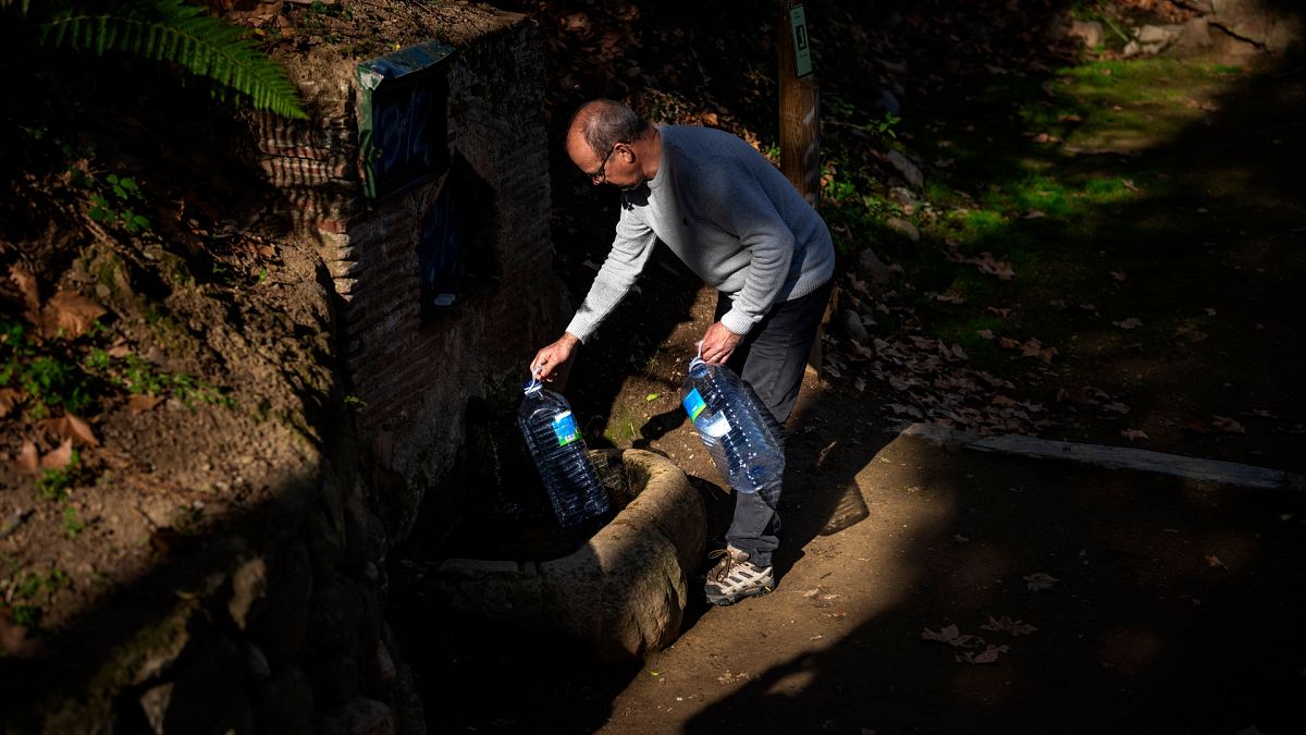 Joan Torrent, 64, füllt Plastikflachen an einer natürlichen Quelle in Gualba. 