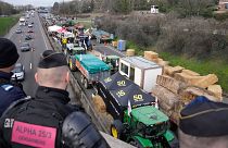 پلیس فرانسه در حال نظاره کردن مسدود شدن یک بزرگراه منتهی به شهر پاریس توسط کشاورزان معترض در روز ۳۱ ژانویه ۲۰۲۴