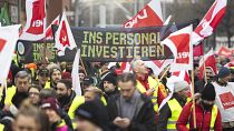 Los participantes en una manifestación de Verdi caminan por el centro de la ciudad de Hannover, Alemania, el 2 de febrero de 2024. La pancarta dice "Invertir en personal".