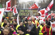 Los participantes en una manifestación de Verdi caminan por el centro de la ciudad de Hannover, Alemania, el 2 de febrero de 2024. La pancarta dice "Invertir en personal".