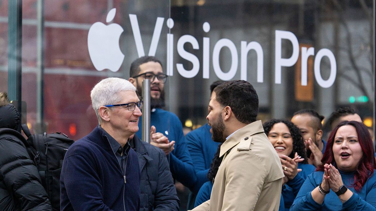 Tim Cook, az Apple vezérigazgatója (balra) az új Apple Vision Pro okosszemüveg iránt érdeklődő ügyfeleket üdvözöl a termék bemutatása során New York-ban 2024. február 2-án. 