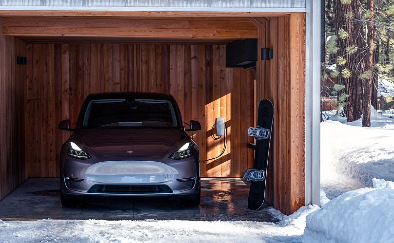 A Tesla Model Y home charging under cover during the winter.
