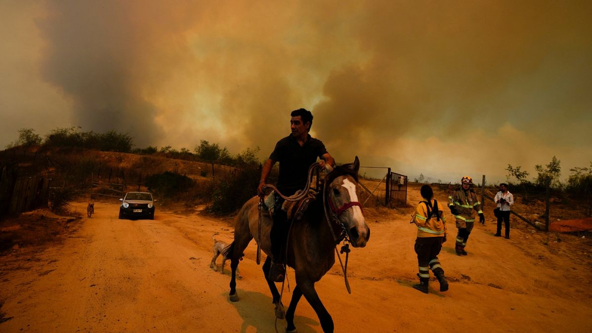 Um morador foge de um incêndio florestal em Vina del Mar, Chile, sábado, 3 de fevereiro de 2024.