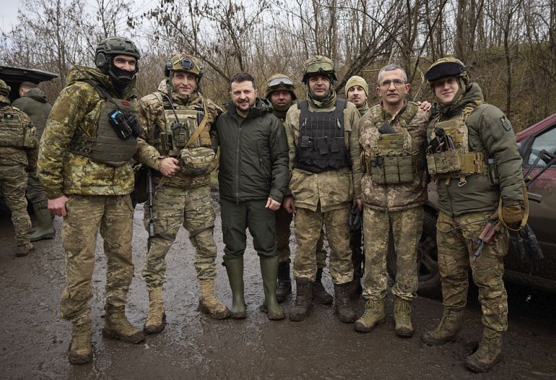 Ukrainian President Volodymyr Zelenskyy, center, poses for a photo with servicemen during his visit to Zaporizhzhia region, the site of fierce battles with the Russian troops.