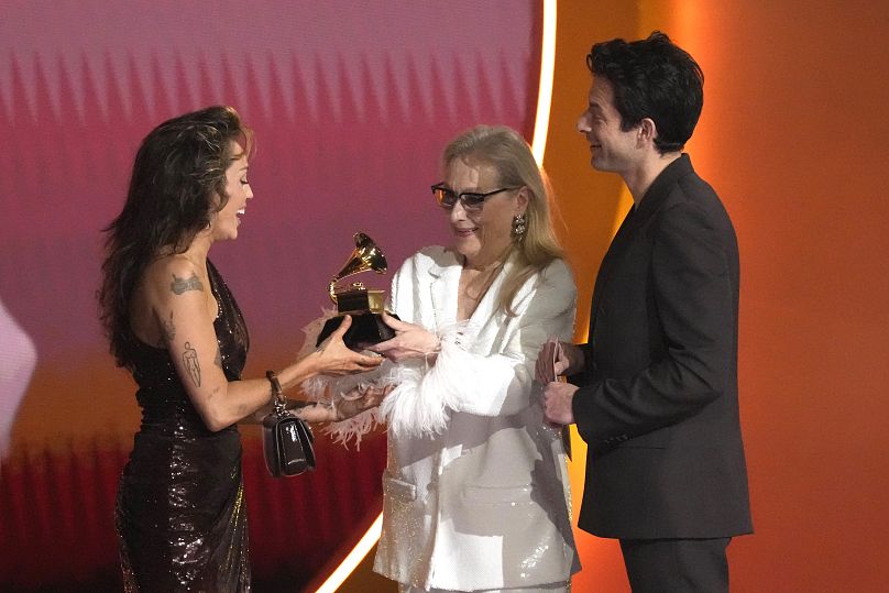 Meryl Streep, center, and Mark Ronson present Miley Cyrus with the award for record of the year