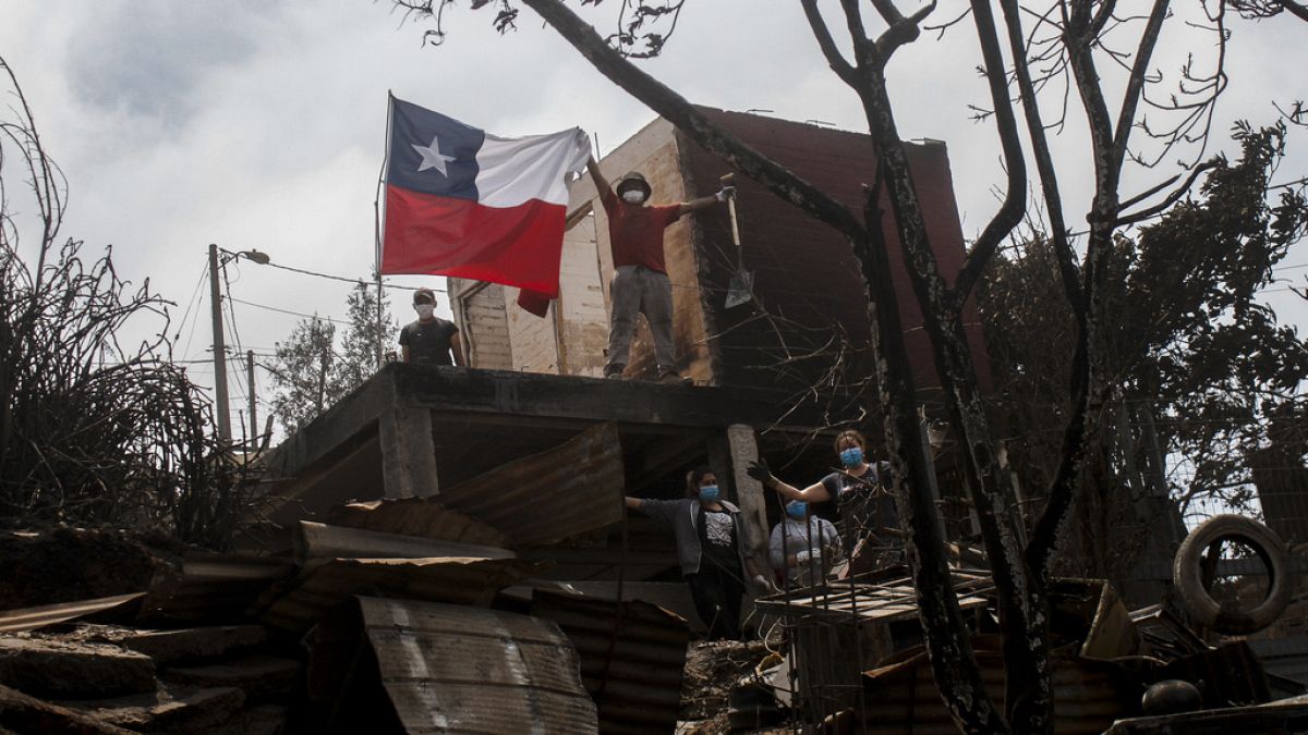 Kiégett ház előtt emelték fel a chilei zászlót a lakók