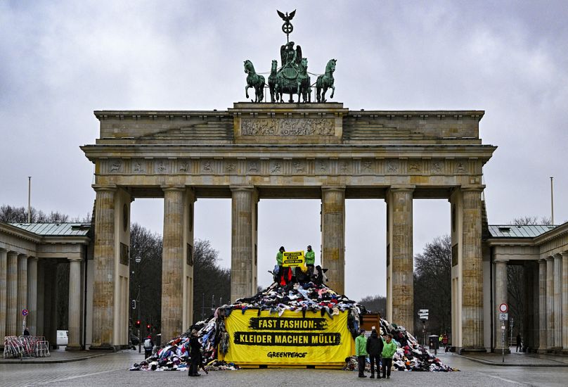 Protesta de Greenpeace contra la industria de la moda frente a la Puerta de Brandenburgo en Berlín