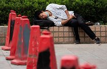 رجل يخفض قناعه وهو يغفو في شوارع بكين