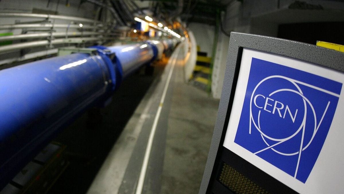 Cartel del CERN junto al colisionador de partículas