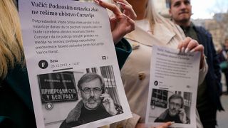 Demonstranten halten Flugblatt zum Fall Slavko Curuvija. 