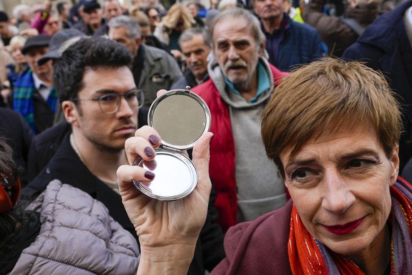 Media rights groups and opposition campaigners hold mirrors during a protest in front of the Serbian appeals court in Belgrade.
