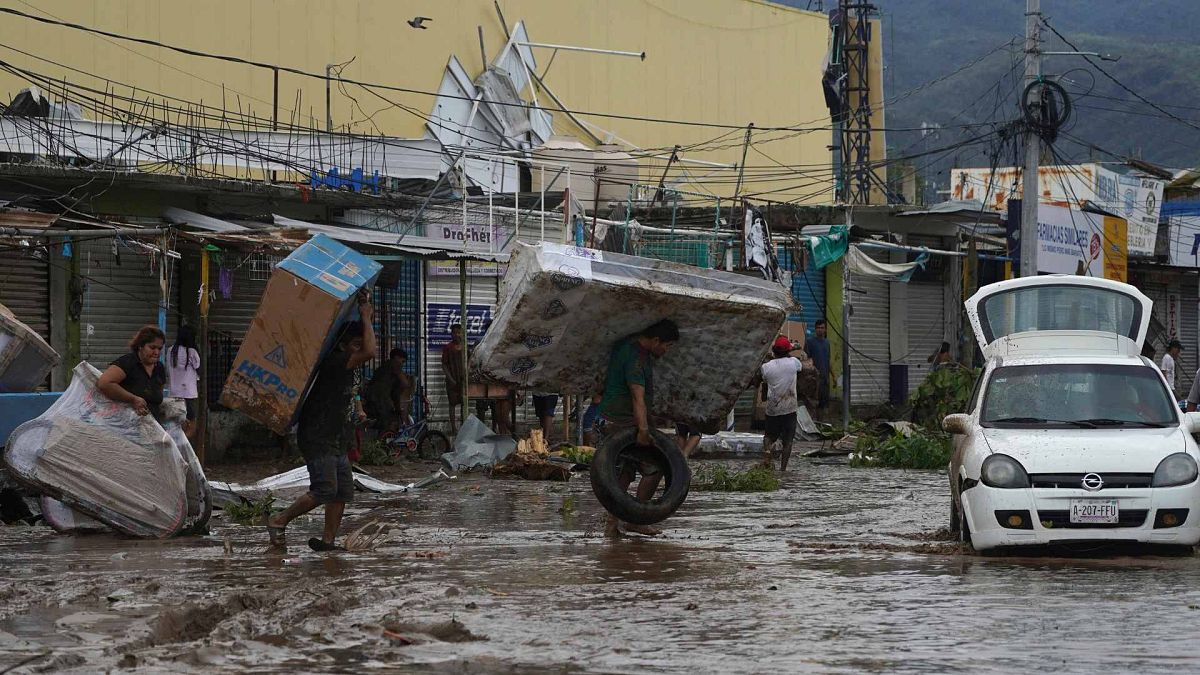 Des personnes emportent un matelas, un écran de télévision et un vélo d'un magasin d'un centre commercial après le passage de l'ouragan Otis à Acapulco, au Mexique, le 25 octobre 2023.