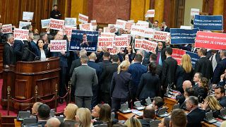 Opposition lawmakers hold banners reading: "Stole the elections" during a Serbia's parliament constitutive session in Belgrade, Serbia, Tuesday, Feb. 6, 2024. 