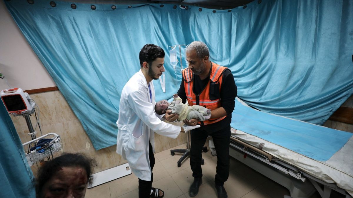 مسعف يحمل مولود أصيب في غارة جوية إسرائيلية على قطاع غزة.