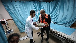 مسعف يحمل مولود أصيب في غارة جوية إسرائيلية على قطاع غزة.