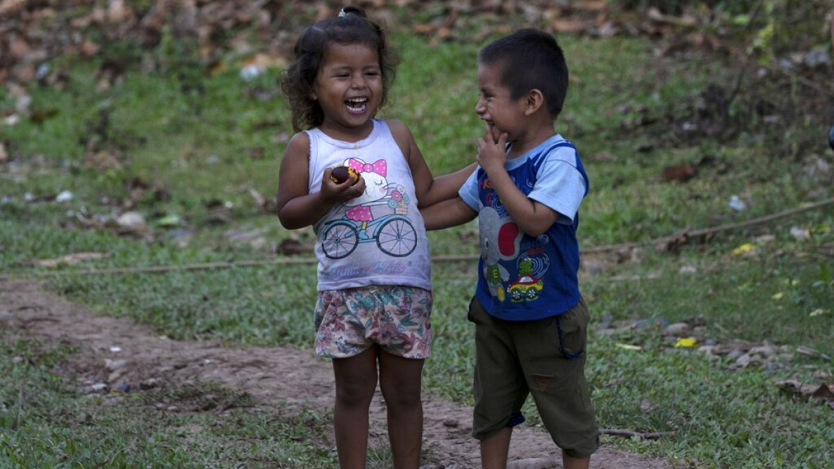 Bambini ridono mentre mangiano un frutto locale nella comunità di Chambira, nell'Amazzonia peruviana