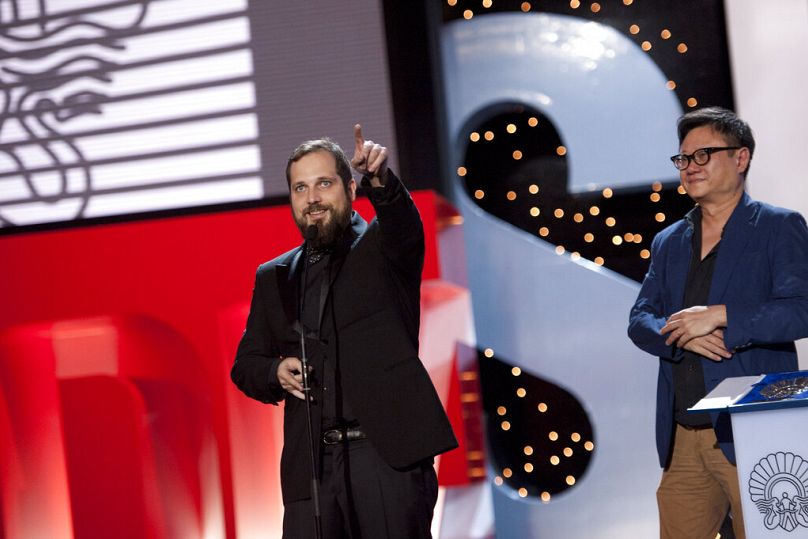 Spanish film director, Carlos Vermut, left, gestures after receiving by member of the Official Jury, Erik Khoo of Singapore, the Silver Shell for the best director.