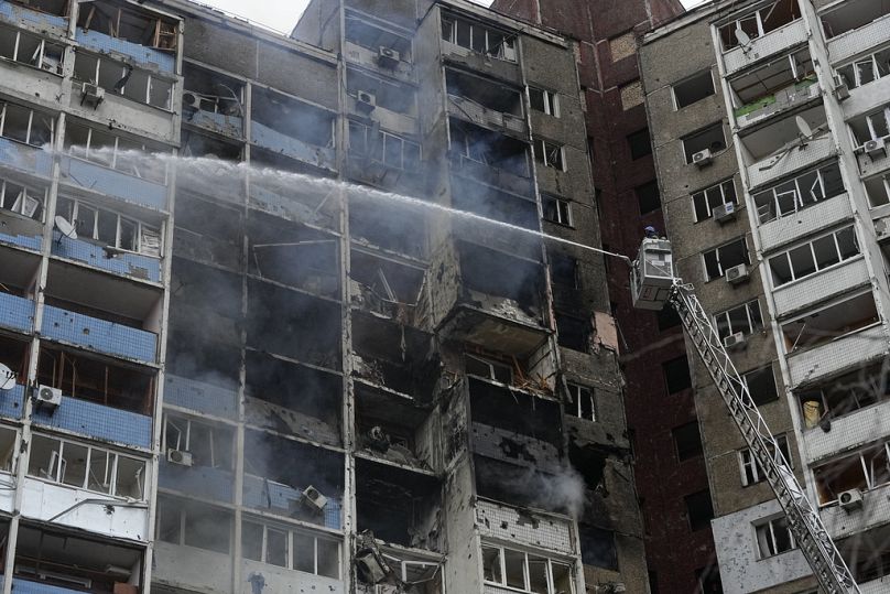İtfaiyeciler Kiev'deki Rus saldırısının ardından bir apartmanda çıkan yangını söndürmeye çalışıyor