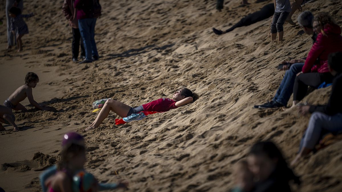 İspanya'nın Barselona kentindeki bir plajda güneşlenen bir kadın, 4 Şubat 2024, Pazar. İspanya'nın hava durumu ajansı, yılın bu zamanı için anormal derecede yüksek sıcaklıklar yaşandığını söylüyor.