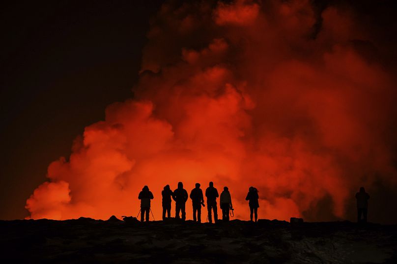 Persone assistono all'eruzione nel nord di Grindavik