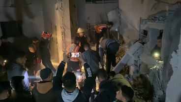 سكان رفح يزيلون الأنقاض من مبنى دمره قصف إسرائيلي.