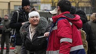 Una mujer herida junto a un edificio destruido después de un ataque ruso 