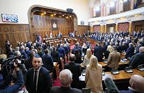 Imagen en la que se puede ver a un grupo de legisladores de pie, para escuchar el himno nacional de Serbia, antes de una sesión constitutiva del Parlamento serbio.