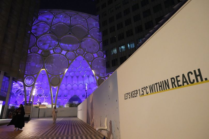 An einer Wand in der Nähe des Al Wasl Dome in der Expo City ist zu lesen: "Halten wir 1,5 Grad Celsius in Reichweite" bei der COP28.
