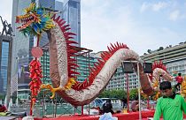 Танцор-дракон выступает на церемонии открытия ежегодной ярмарки в Храме Земли