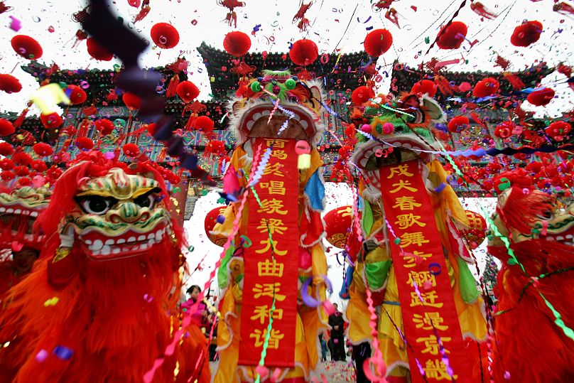 Artistas chinos vestidos con trajes tradicionales de león en Beijing