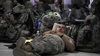 جندي في الجيش الأمريكي يأخذ قيلولة داخل صالة الركاب في قاعدة سثر الجوية في بغداد، العراق