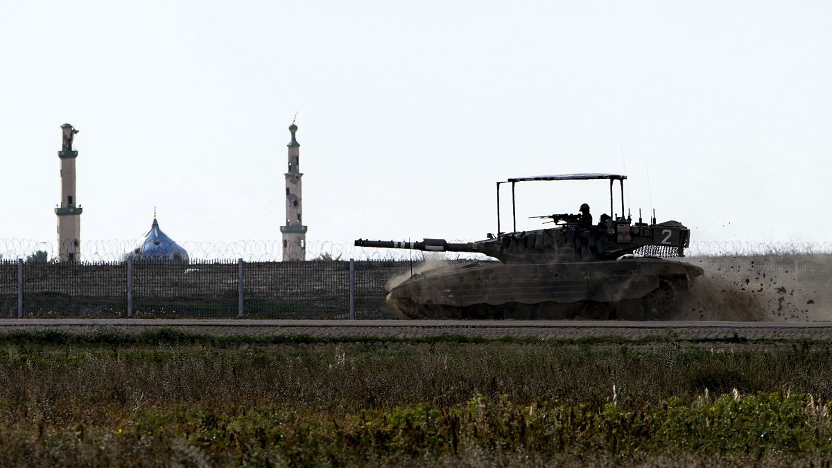 دبابة إسرائيلية تمر من أمام جامع في قطاع غزة