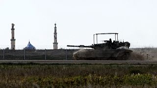 دبابة إسرائيلية تمر من أمام جامع في قطاع غزة