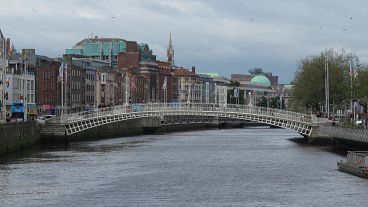 The River Liffey flows past the Ha'penny Bridge in Dublin, Ireland