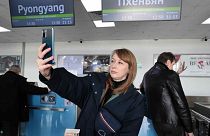 Um turista russo tira uma selfie depois de fazer o check-in para embarcar num avião com destino à Coreia do Norte, no aeroporto internacional de Vladivostok, sexta-feira, 9 de fevereiro de 2024