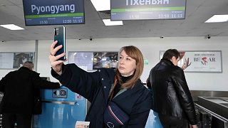 A Russian tourist takes a selfie after checking-in to board a plane to fly to North Korea, at the international airport outside in Vladivostok, Friday, Feb. 9, 2024
