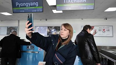 Российская туристка делает селфи после регистрации на самолет в Северную Корею в аэропорту Владивостока, 9 февраля 2024 года