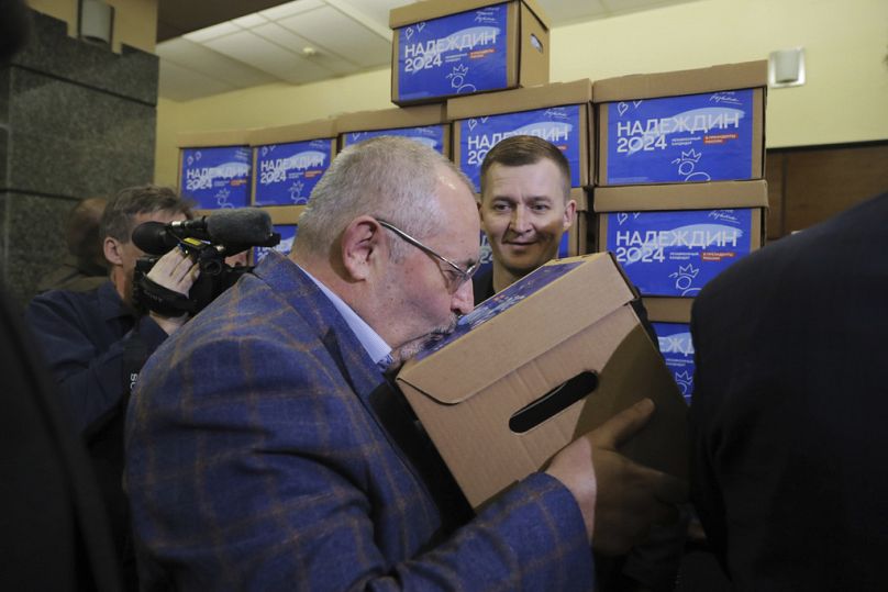 Boris Nadezhdin kisses a box with subscription sheets with signatures gathered for him for the upcoming presidential election in Moscow, February 2024