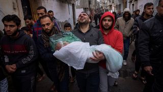 الفلسطيني محمد شومان يحمل جثمان ابنته ماسة التي قُتلت في قصف إسرائيلي على قطاع غزة وشُيعت في رفح