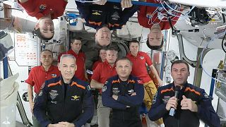 Τα 11 μέλη του πληρώματος του Διεθνούς Διαστημικού Σταθμού που εκπροσωπούν τα πληρώματα της Expedition 70 (κόκκινα πουκάμισα) και του Axiom Space 3 (σκούρες μπλε στολές) συγκεντρώνονται για την αποχαιρετιστήρια τελετή.