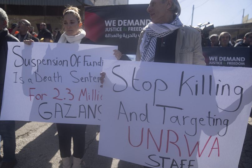Palestinos protestan contra la suspensión de fondos de varios países donantes al OOPS frente a las oficinas del Organismo en la ciudad de Beitunia, febrero de 2024.
