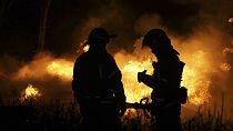 Due pompieri spengono un incendio in un'area residenziale di Kharkiv, in Ucraina, dopo un attacco russo