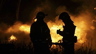 Due pompieri spengono un incendio in un'area residenziale di Kharkiv, in Ucraina, dopo un attacco russo